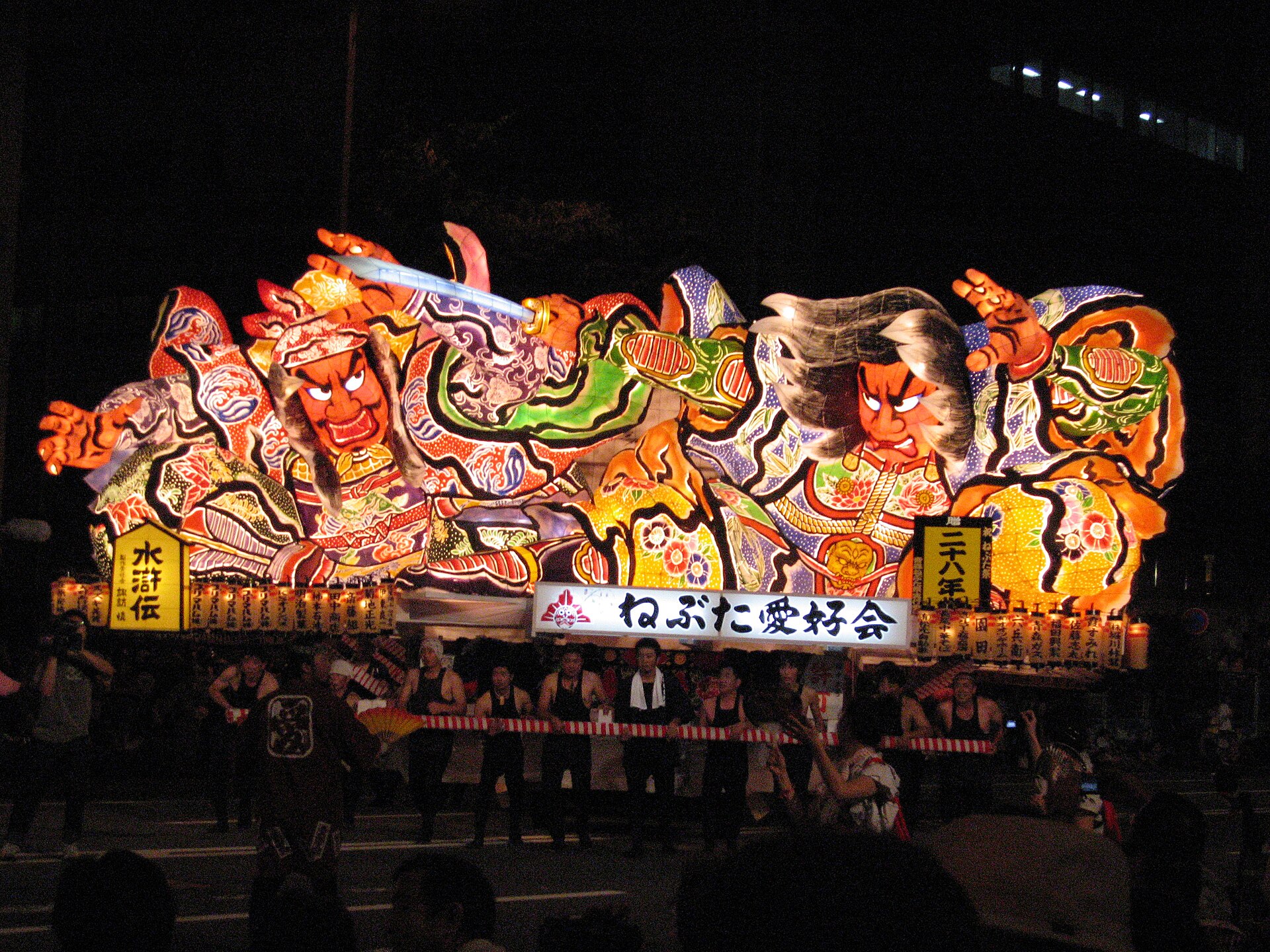 2006年青森睡魔祭，一台通体发光的巨大睡魔灯笼花车在夜色中巡游。