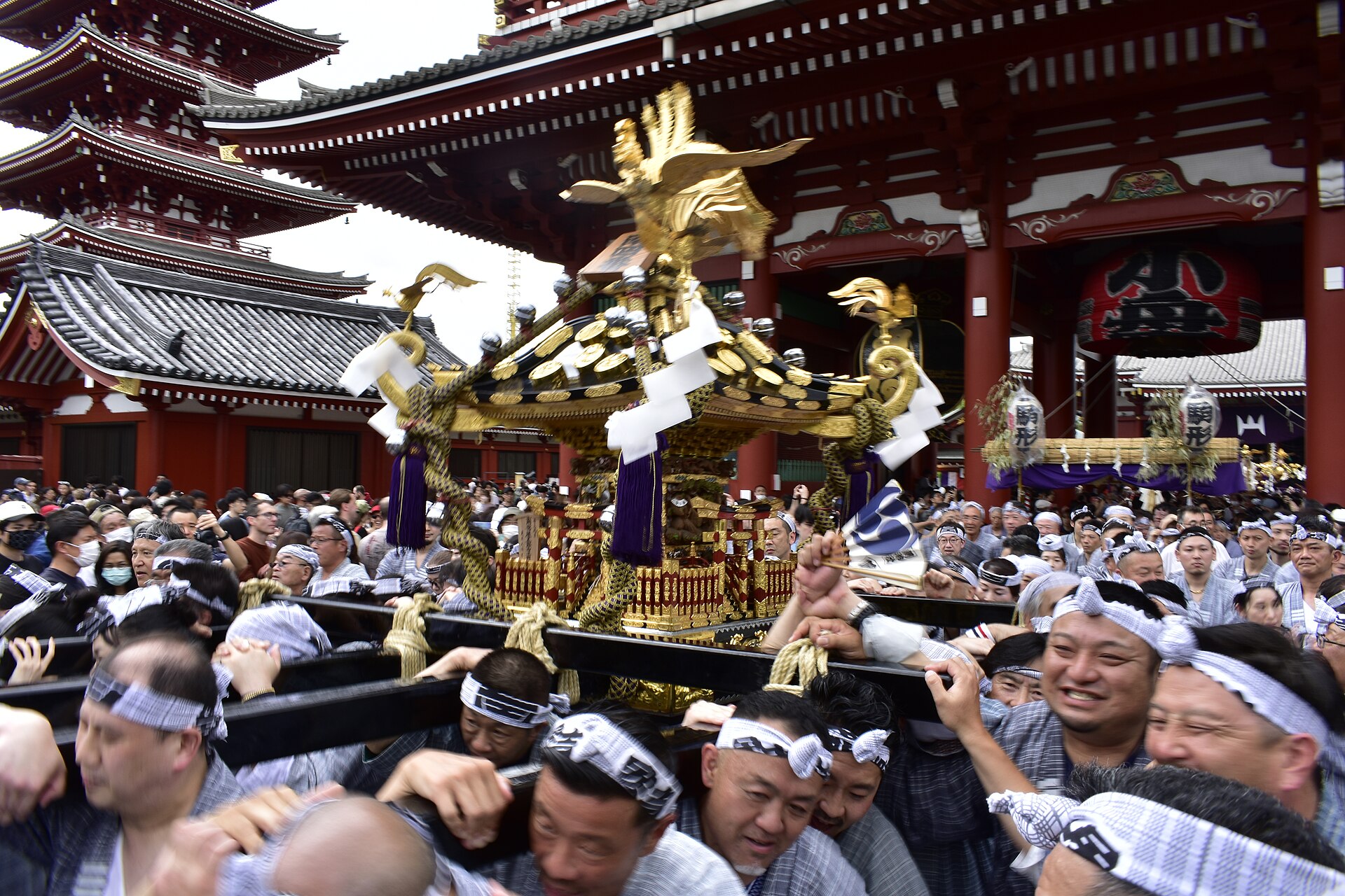 2023年三社祭上，人们抬着金色神轿经过浅草寺宝藏门。