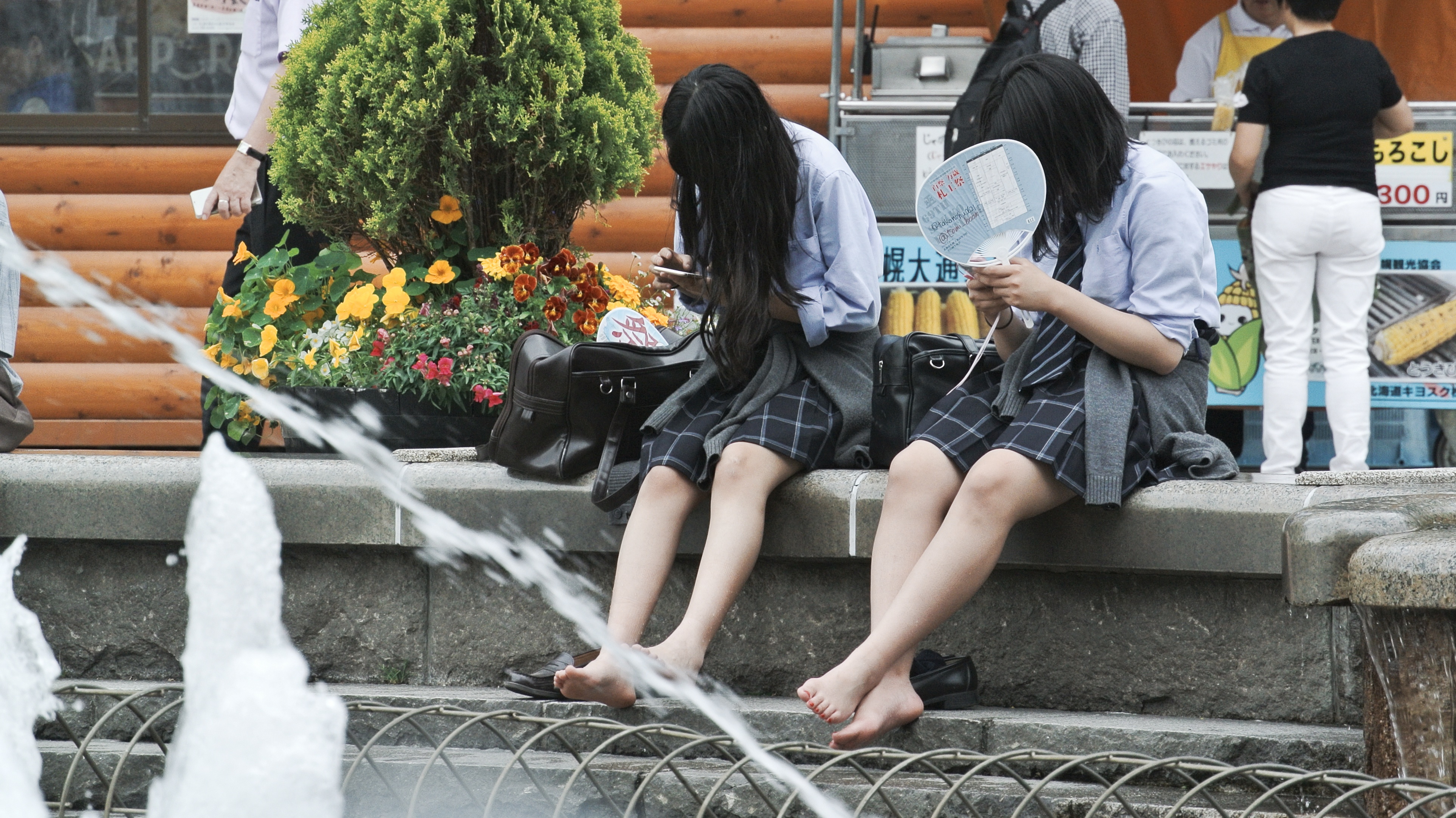夏日札幌大通公园喷泉中戏水的学生。