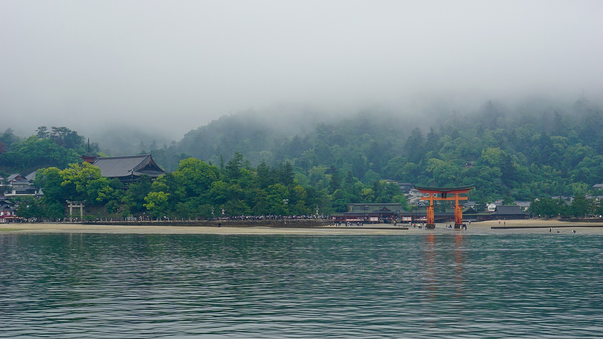 严岛神社的大鸟居在雾气中若隐若现，立于宫岛海边。