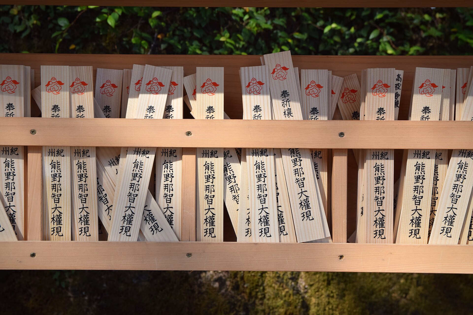 浅色木架上密密排列着写有“奉祈祷 纪州熊野那智大权现”、盖有红色徽记的木制祈愿札。
